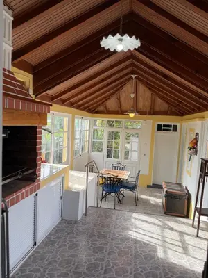 a patio with a table and chairs and a ceiling at Casa da Cruz in Ponta do Sol