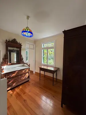 an empty living room with a piano and a table at Casa da Cruz in Ponta do Sol