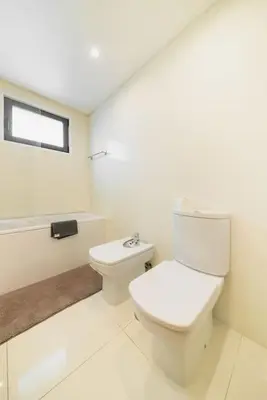a white bathroom with a toilet and a window at Esmael Apartment 2 by Mth in Funchal