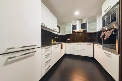 a white kitchen with white cabinets and black appliances at Esmael Apartment 2 by Mth in Funchal