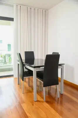 a dining table with four chairs and a laptop on it at Esmael Apartment 2 by Mth in Funchal