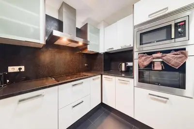 a kitchen with white cabinets and a microwave at Esmael Apartment 2 by Mth in Funchal