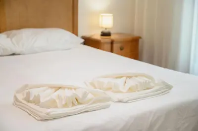 a white bed with two folded towels on it at Esmael Apartment 2 by Mth in Funchal
