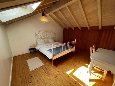 a bedroom with a bed in a attic at Aljezur Bordeira Houses 3 bedrooms 2 bathrooms with Condo Pool in Bordeira