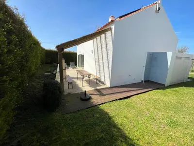 a small white building with a picnic table on a deck at Aljezur Bordeira Houses 3 bedrooms 2 bathrooms with Condo Pool in Bordeira