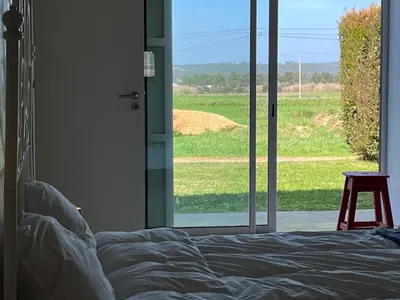 a bedroom with a bed and a view of a field at Aljezur Bordeira Houses 3 bedrooms 2 bathrooms with Condo Pool in Bordeira