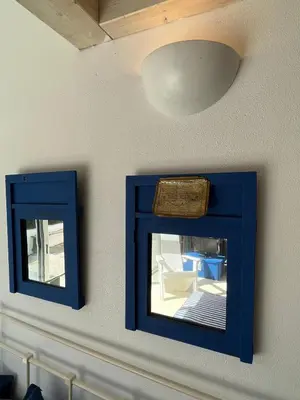two blue mirrors on a wall with a light at Aljezur Bordeira Houses 3 bedrooms 2 bathrooms with Condo Pool in Bordeira