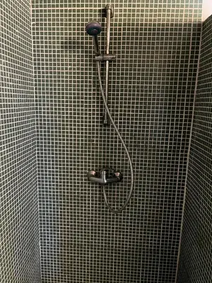a shower with a hose in a tiled bathroom at Aljezur Bordeira Houses 3 bedrooms 2 bathrooms with Condo Pool in Bordeira