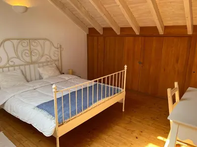a bedroom with a white bed and a wooden floor at Aljezur Bordeira Houses 3 bedrooms 2 bathrooms with Condo Pool in Bordeira