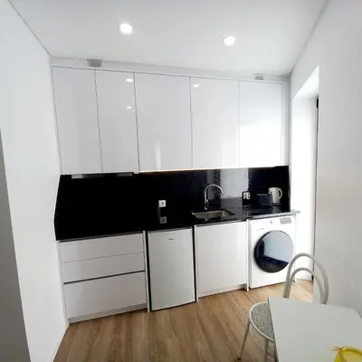 a white kitchen with white cabinets and a sink at Casa Rodrigues in Madalena do Mar