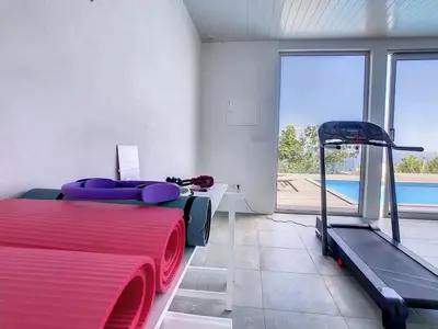 a room with a bed and a treadmill and a pool at New Villa Piece of Heaven by Your Madeira Rentals in Estreito da Calheta