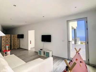a living room with a white couch and a tv at New Villa Piece of Heaven by Your Madeira Rentals in Estreito da Calheta