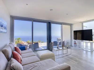 a living room with a couch and a flat screen tv at New Villa Piece of Heaven by Your Madeira Rentals in Estreito da Calheta