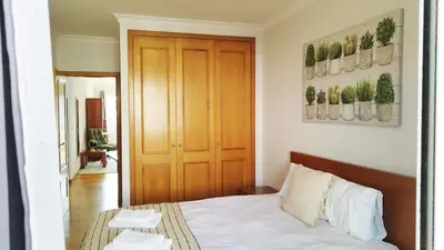 a bedroom with a bed and a wooden door at MCStylo-Vista Oceano in Caniço