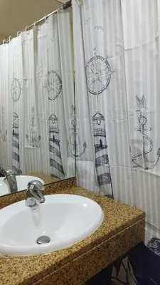 a bathroom with a sink and a shower curtain at MCStylo-Vista Oceano in Caniço