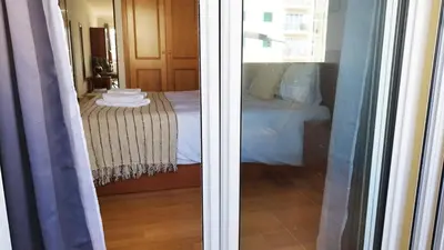 a view of a bedroom with a bed through a window at MCStylo-Vista Oceano in Caniço