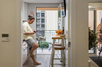 a man standing on a balcony looking at his cell phone at Carmo - Moon in Funchal