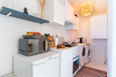 a kitchen with white cabinets and a microwave at GREEN OASIS FUNCHAL HOUSE WITH 2 PRIVATE APARTMENTS and TERRACE in Funchal