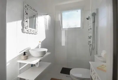 a white bathroom with a sink and a toilet at GREEN OASIS FUNCHAL HOUSE WITH 2 PRIVATE APARTMENTS and TERRACE in Funchal
