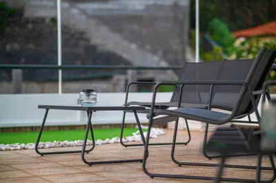 a black chair and a table on a patio at GREEN OASIS FUNCHAL HOUSE WITH 2 PRIVATE APARTMENTS and TERRACE in Funchal