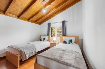 two beds in a room with a window at Casa Katy by Atlântica in Calheta