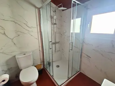 a bathroom with a toilet and a glass shower at Casa Katy by Atlântica in Calheta