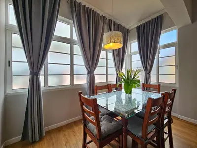 a dining room with a glass table in front of windows at Sunny House Funchal in Funchal