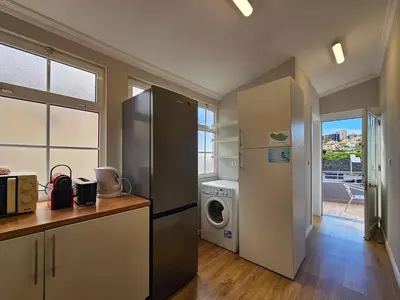 a kitchen with a refrigerator and a washing machine at Sunny House Funchal in Funchal