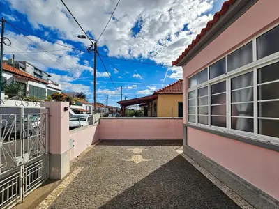 a balcony of a pink house with a fence at Sunny House Funchal in Funchal