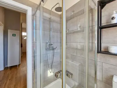 a bathroom with a shower with a glass door at Sunny House Funchal in Funchal