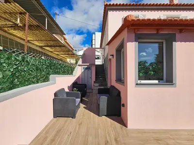a house with two chairs and a window at Sunny Terrace Funchal in Funchal