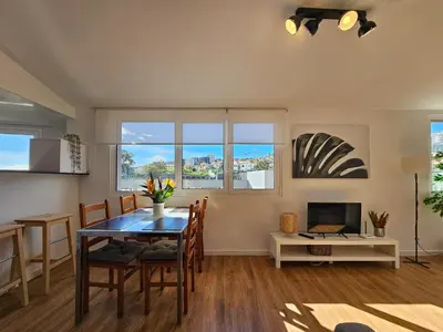 a dining room with a table and chairs and a television at Sunny Terrace Funchal in Funchal