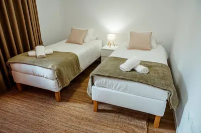 a room with two beds and a chair in it at Villa Arrifes Porto Santo in Porto Santo