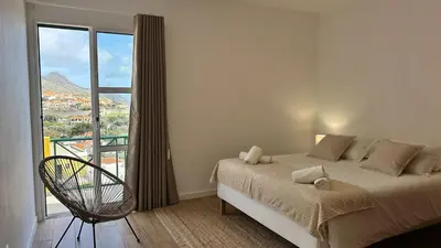 a bedroom with a bed and a large window at Villa Arrifes Porto Santo in Porto Santo