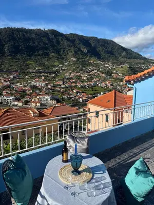 a table on a balcony with a view of a city at Sea & Mountain View Home in Machico in Machico