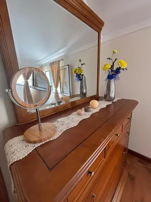 a mirror on top of a wooden dresser with vases at Sea & Mountain View Home in Machico in Machico