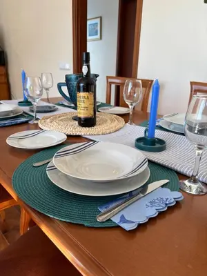 a table with plates and a bottle of wine on it at Sea & Mountain View Home in Machico in Machico