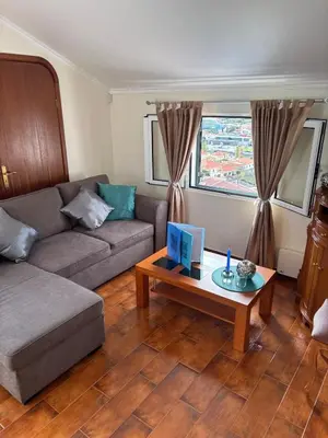 a living room with a couch and a coffee table at Sea & Mountain View Home in Machico in Machico