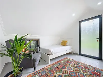a bedroom with a bed and a chair and a plant at Villa Paixao by Atlantic Holiday in Machico