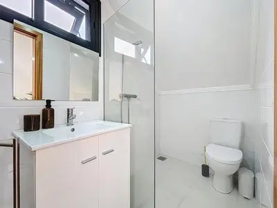 a white bathroom with a toilet and a sink at Villa Paixao by Atlantic Holiday in Machico