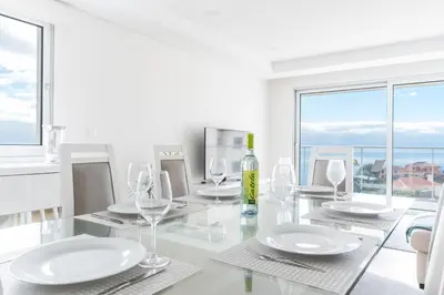a dining room with a glass table with a bottle of wine at Horizonte Completo II by Atlantic Holiday in Câmara de Lobos