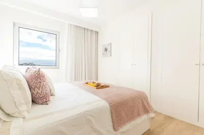 a white bedroom with a bed and a window at Horizonte Completo II by Atlantic Holiday in Câmara de Lobos