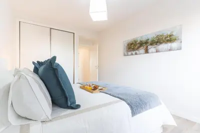 a bedroom with a bed with blue and white pillows at Horizonte Completo II by Atlantic Holiday in Câmara de Lobos
