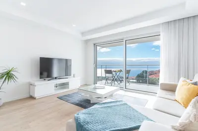 a living room with a white couch and a large window at Horizonte Completo II by Atlantic Holiday in Câmara de Lobos