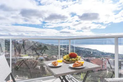a table with two plates of food on a balcony at Horizonte Completo II by Atlantic Holiday in Câmara de Lobos