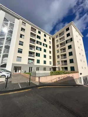 a large white building on the side of a street at Refugio do Ferreirinha in Caniço