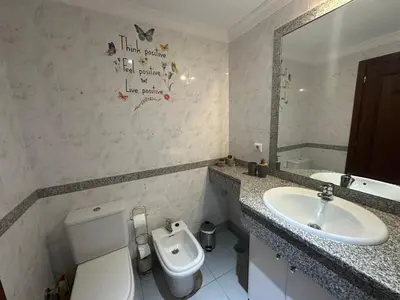 a bathroom with a white toilet and a sink at Refugio do Ferreirinha in Caniço