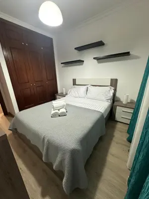a bedroom with a large bed with towels on it at Refugio do Ferreirinha in Caniço