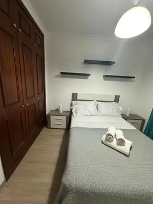 a bedroom with a bed with a pair of shoes on it at Refugio do Ferreirinha in Caniço