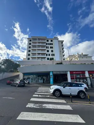 a white car parked in a parking lot in front of a building at Refugio do Ferreirinha in Caniço